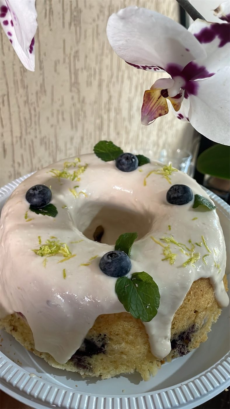 Bolo de mirtilo com cobertura clara e raspas de limão