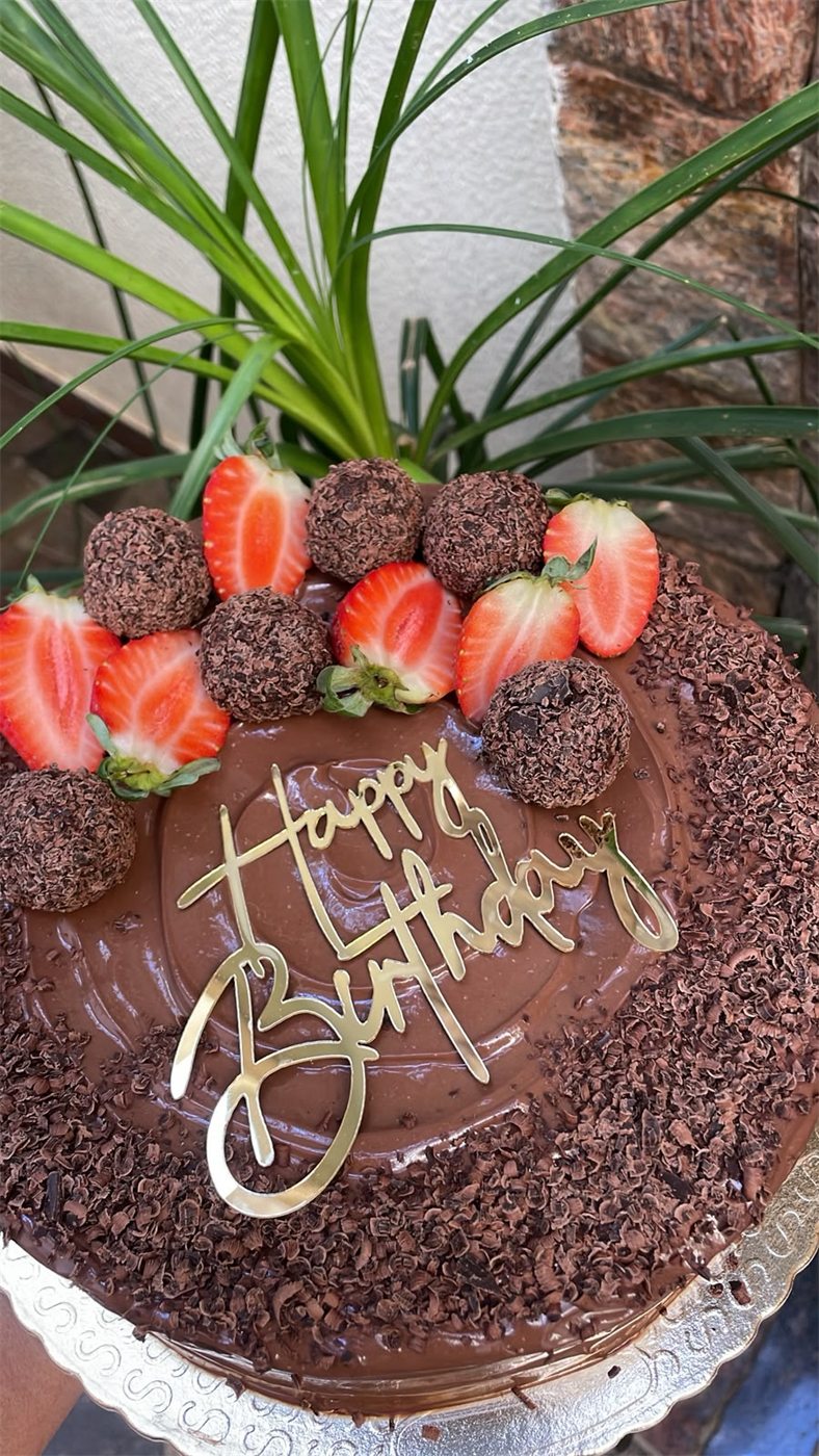 Bolo de chocolate decorado com morangos e brigadeiros